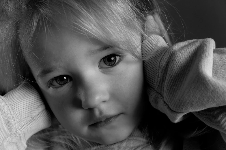 a child with long blonde hair is posing for a po