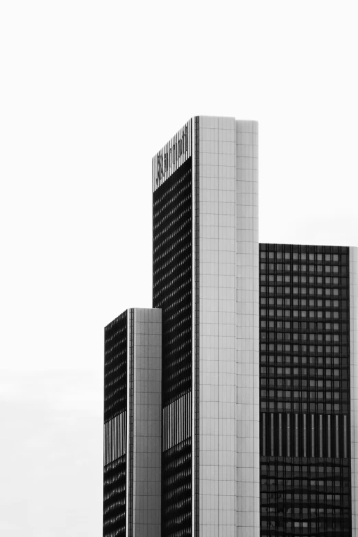 three tall buildings in the city, with a cloudy sky