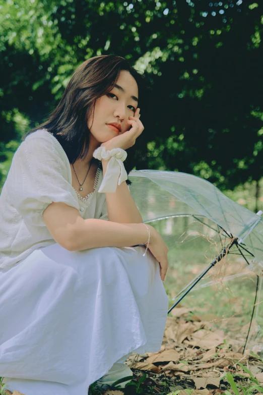 a  in a white dress holding an umbrella