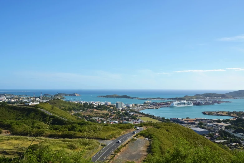 a view of an ocean and mountains, with a city in the distance