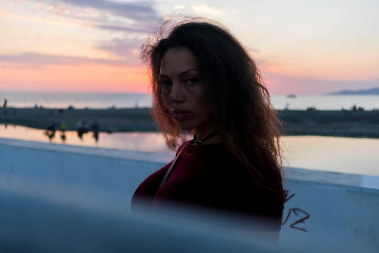 a beautiful young woman in front of a sunset