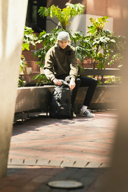 a man sits on a bench while looking at his phone