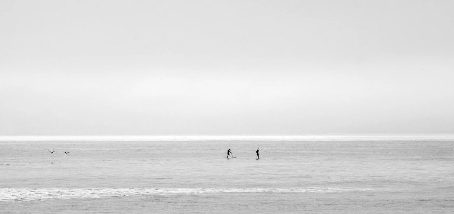 the airplane is flying over the ocean while some are fishing