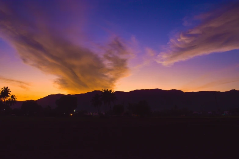 a colorful sunset in the distance over a mountain