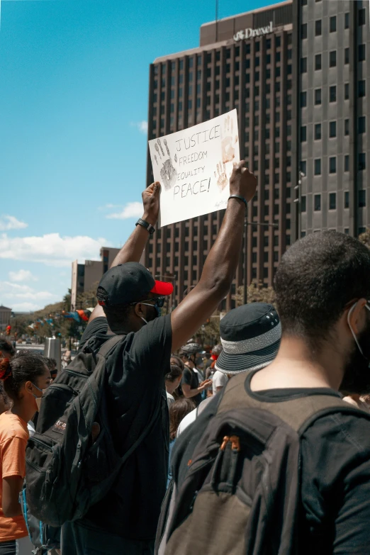 a group of men holding up signs with a sky background