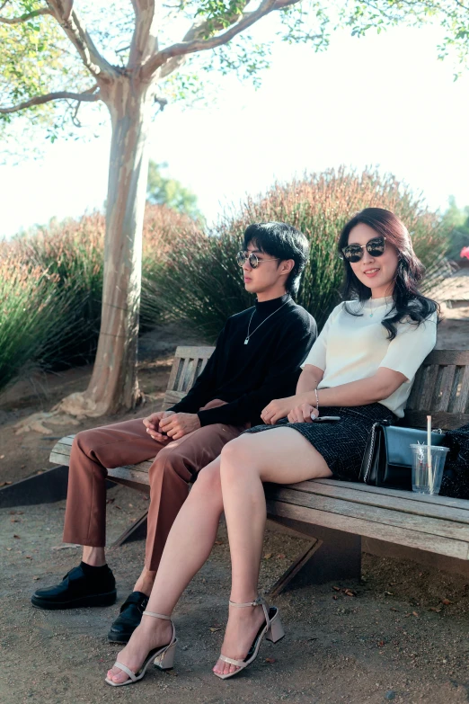 a couple is sitting on a park bench