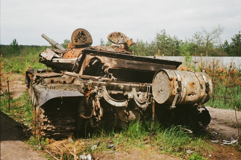 a rusty truck is parked near some weeds