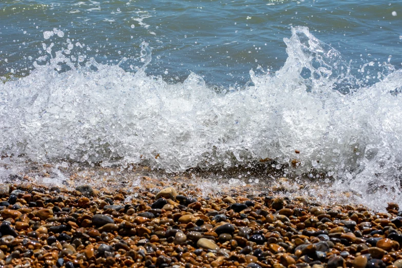 a large body of water is near some rocks and sand