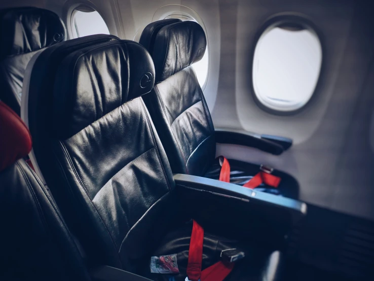 the seats of an airplane with one red seat in front