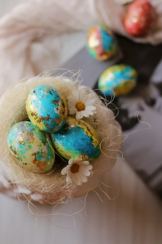 several decorated eggs sitting on top of some hay