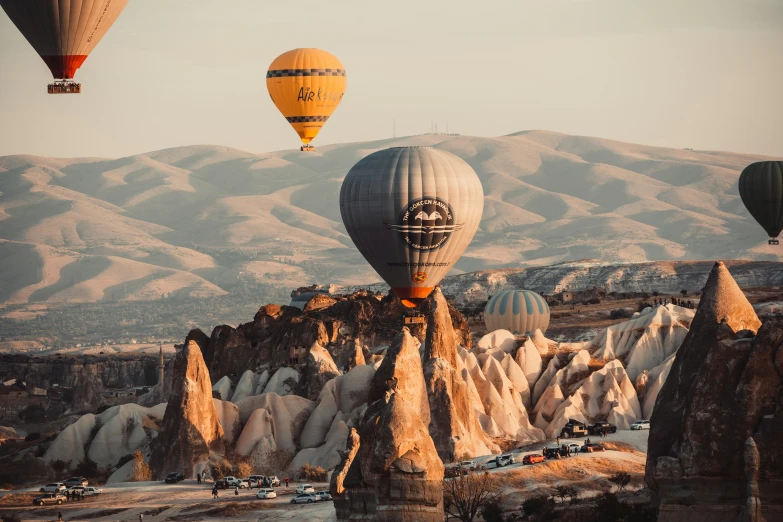 a few  air balloons flying over a mountain valley