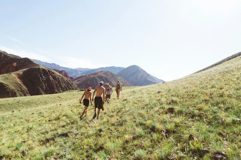 people in shorts are walking along a trail in the mountains