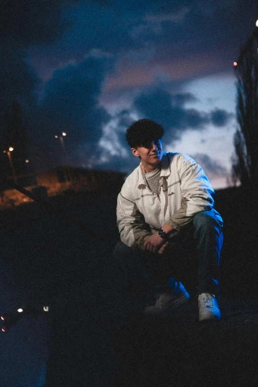 a person sitting down on the ground in the dark