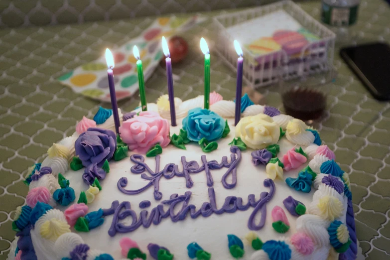 a birthday cake decorated with roses and candles