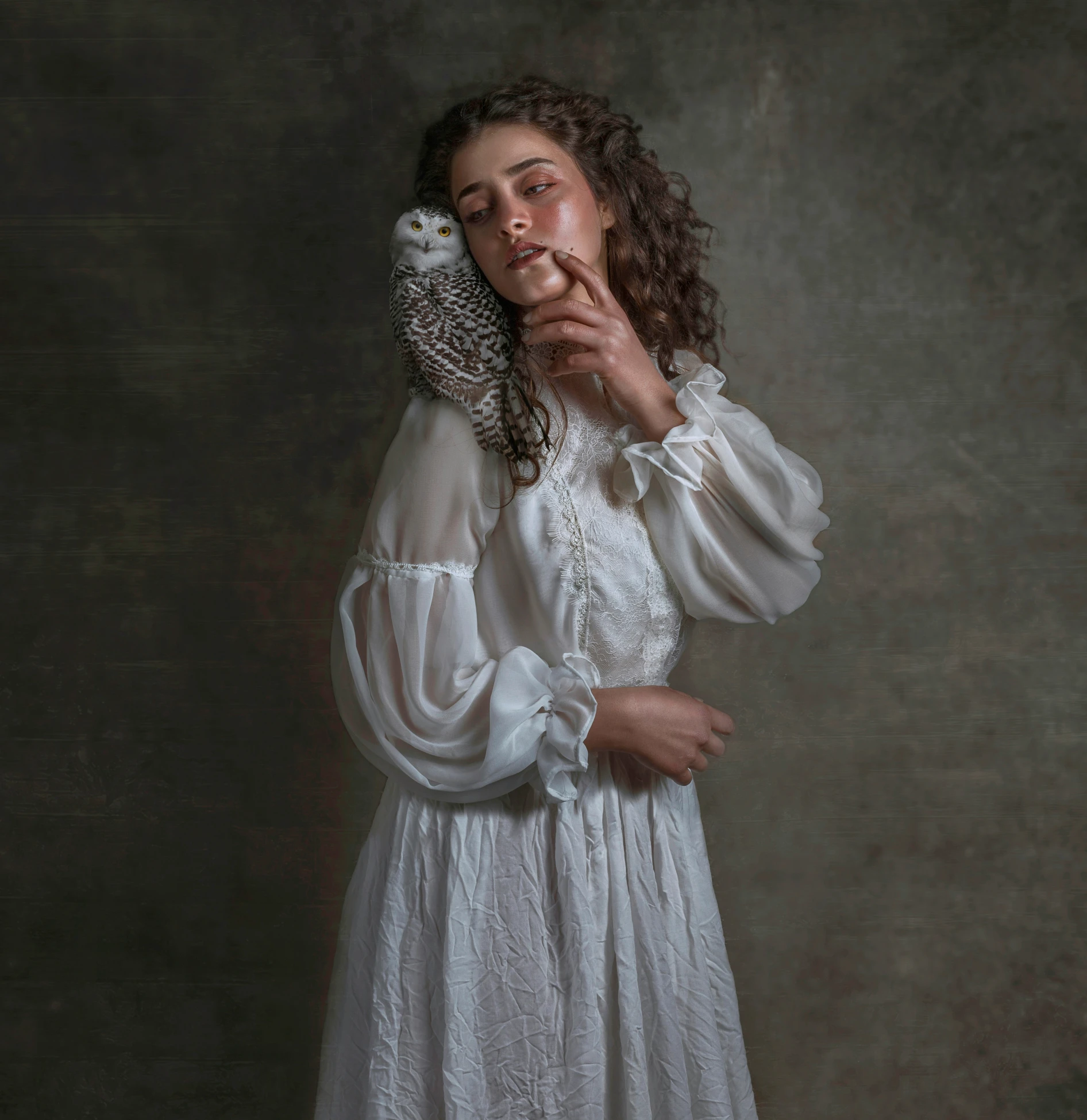 a young woman dressed in white is covering her face with one hand