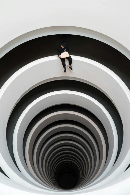 a person in a white shirt stands on a circular object