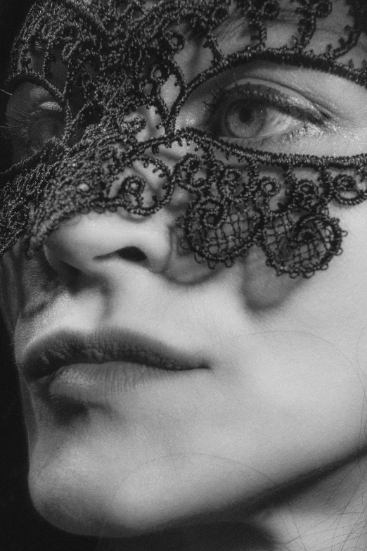 black and white pograph of woman wearing lace mask