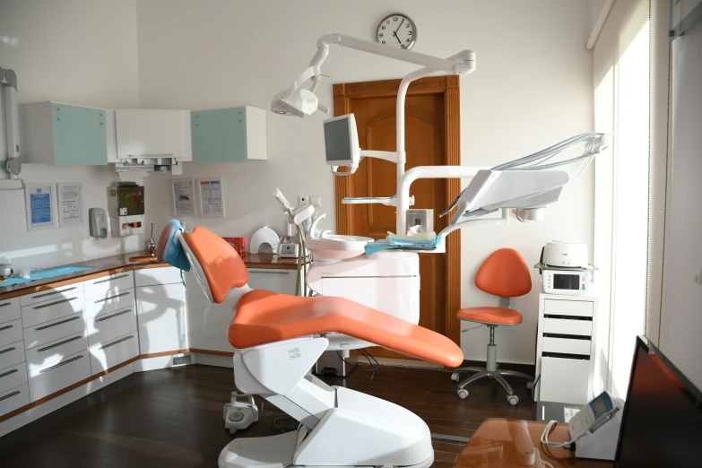 an orange dental chair in a white and wood room