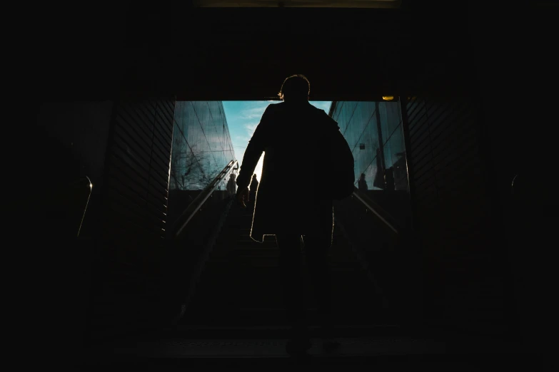 a man on an escalator under a building with a flashlight on