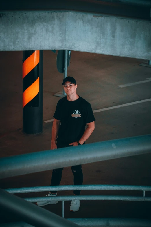 man wearing black shirt standing next to traffic cones