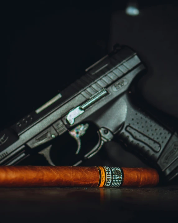 a cigar sits next to a gun on the table