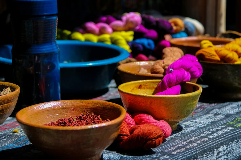 bowls and bowls containing different colored yarns on a table