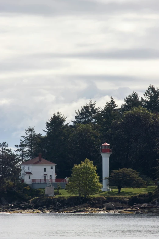 an image of a lighthouse at the edge of a lake