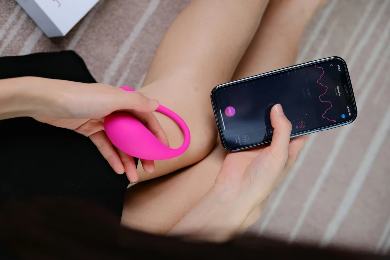 a woman is using a cell phone with a pink finger on it