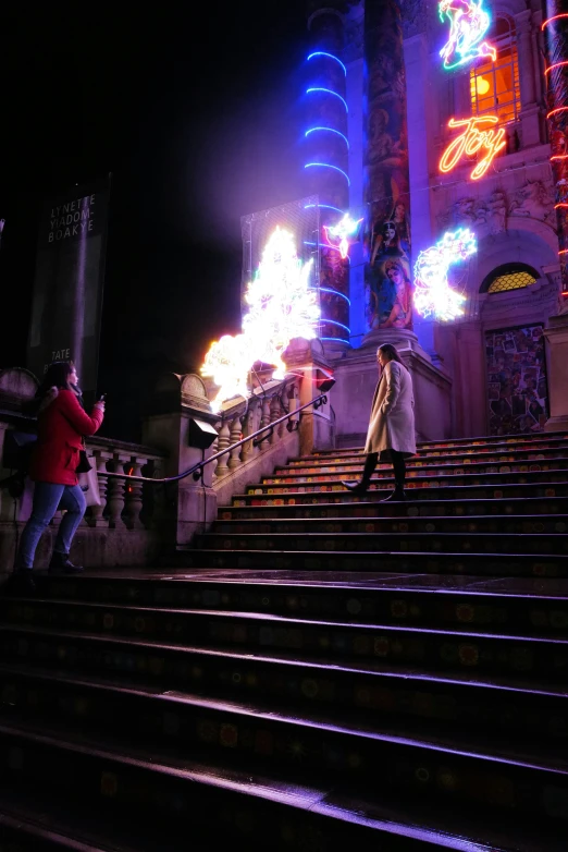 people walking on steps by a building during the night