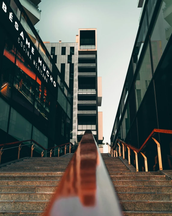 a stairway near several modern buildings with a large sign