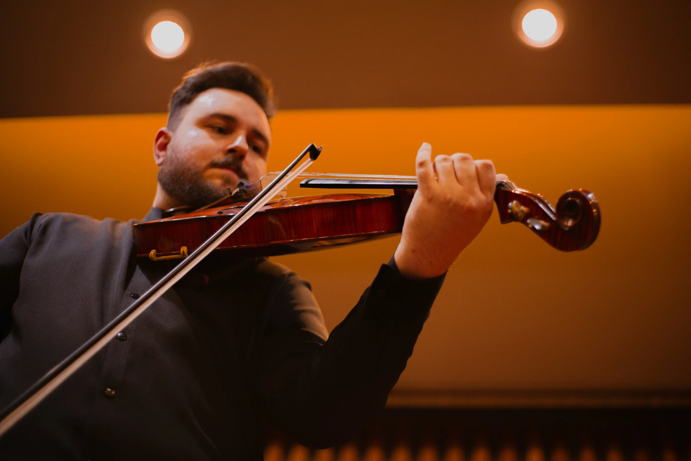 a man in a suit playing the violin