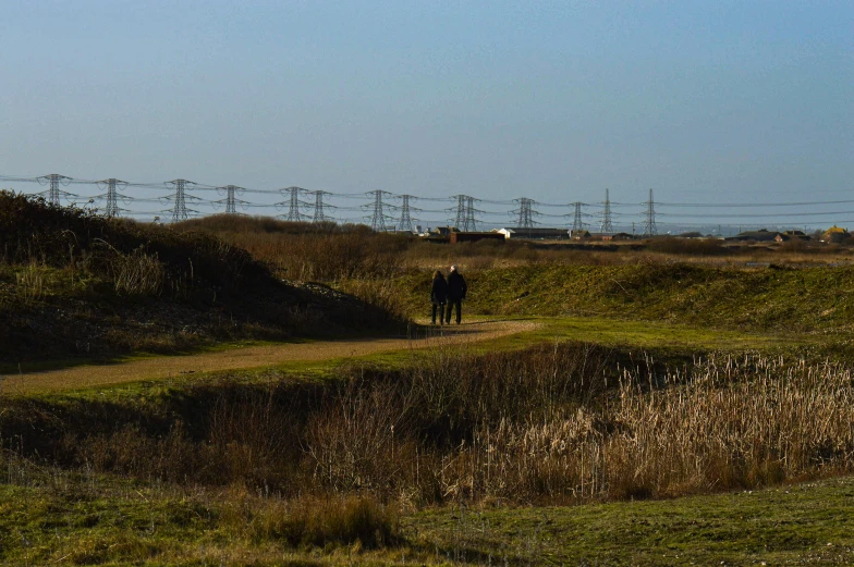 some people walking down a path in an open field