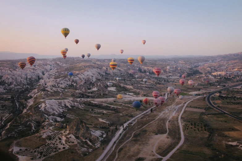 a group of balloons in the sky above a road