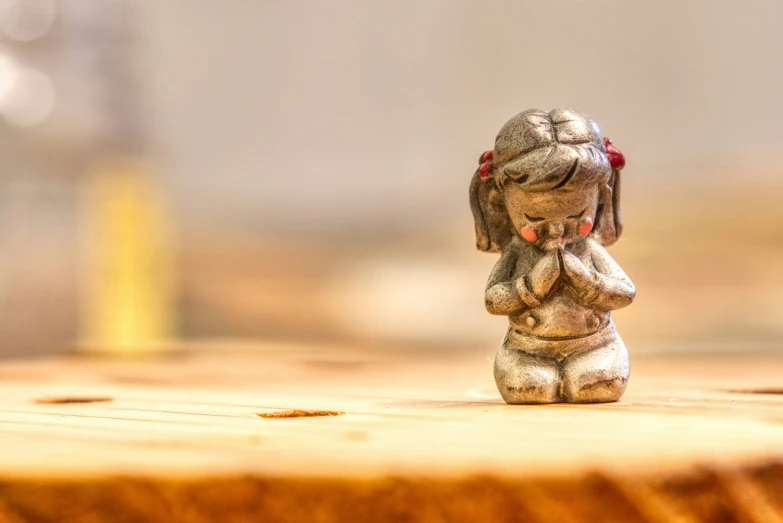 a little figurine standing on top of a wooden table