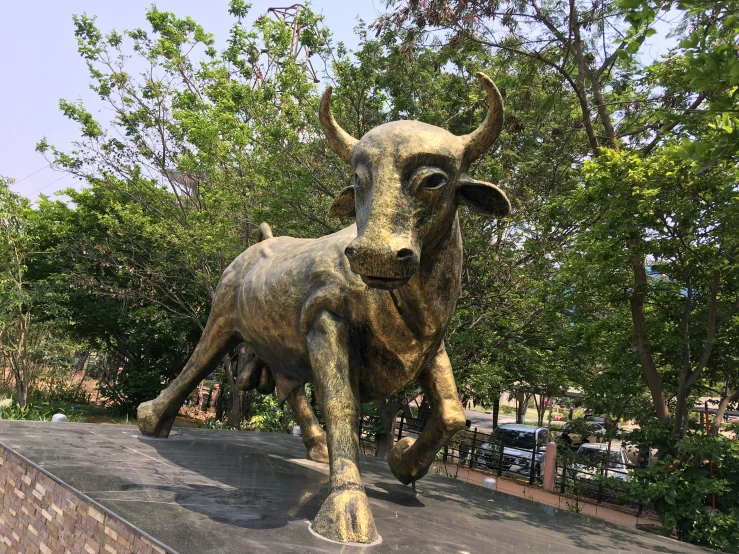 a statue of a bull standing on top of a cement block