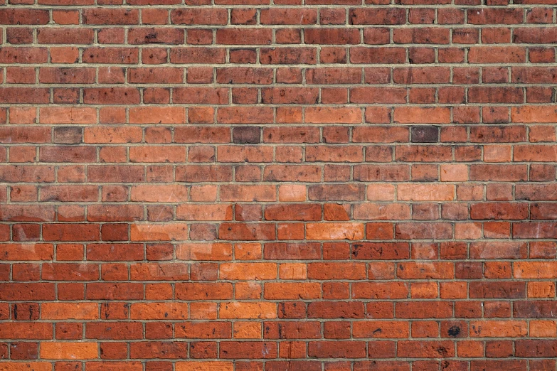 brick wall with orange paint peeling off and s on the side