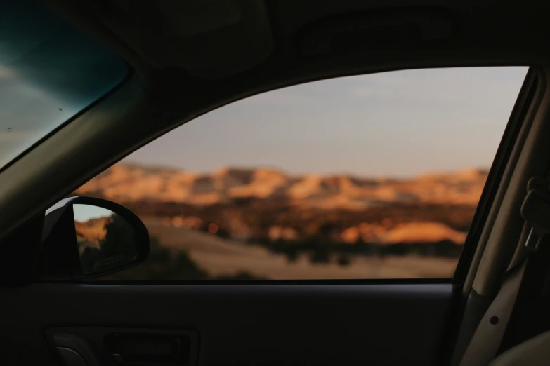 the interior view of a vehicle with a mountain in the background