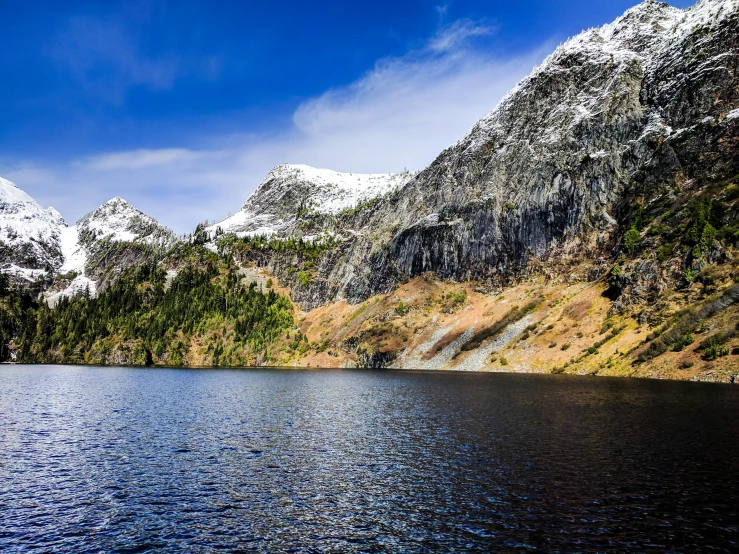 two men are fishing with mountains in the background