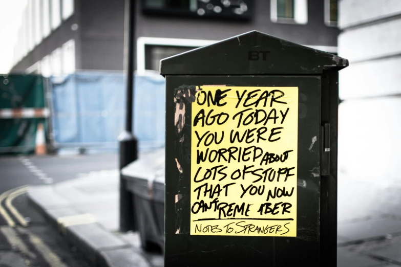 a box on the street next to a sign