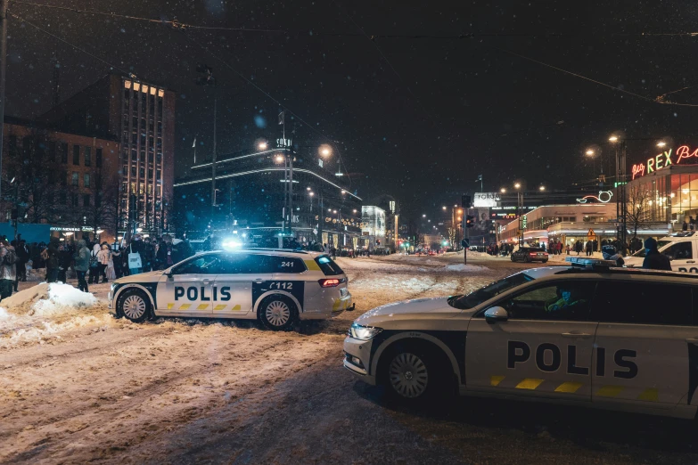 police cars on a snowy city street at night