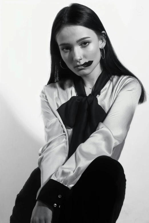 a woman sitting down with a black and white tie