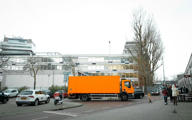 several cars and a yellow truck parked on the side of a road