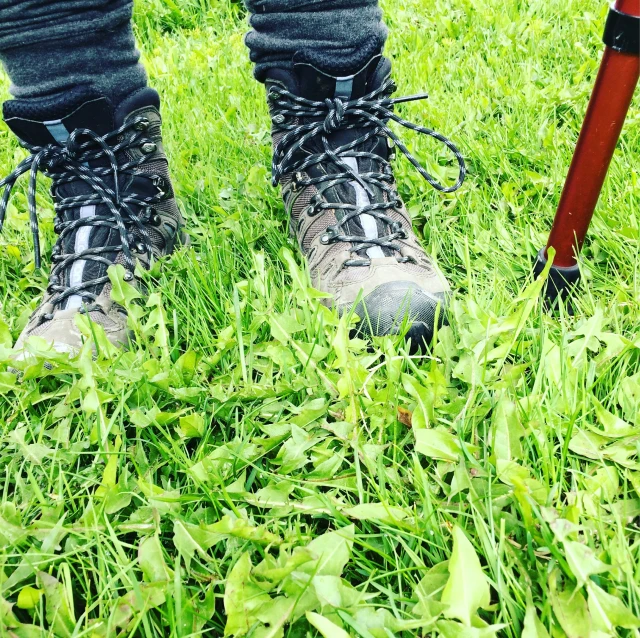 a person standing on some grass with an umbrella