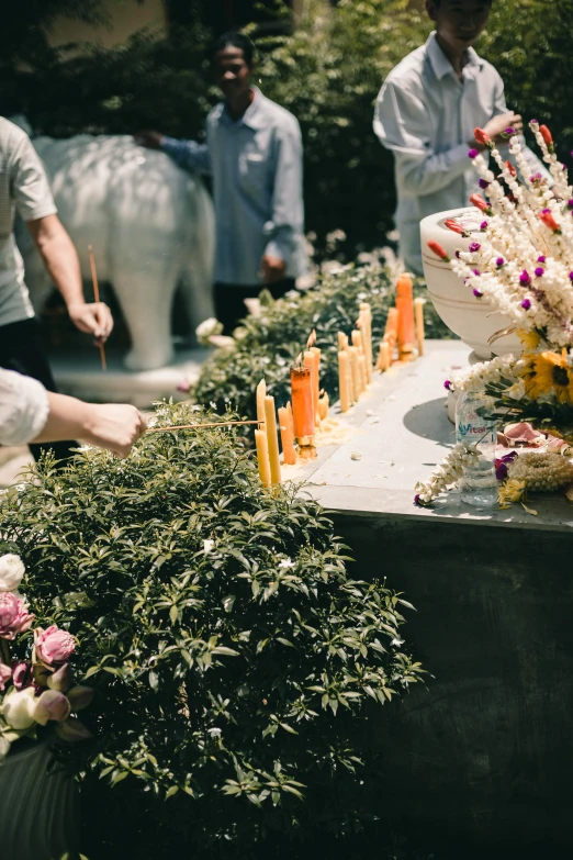 several people stand around candles on the table