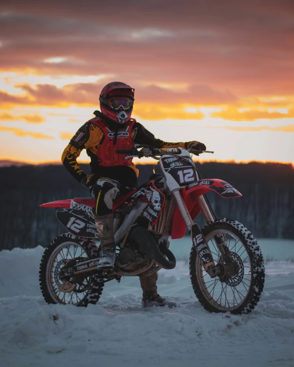 a person on a motorcycle standing in the snow