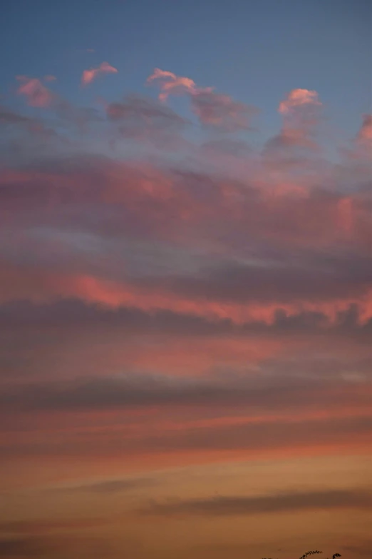 a very large contrails flying in the sky during sunset