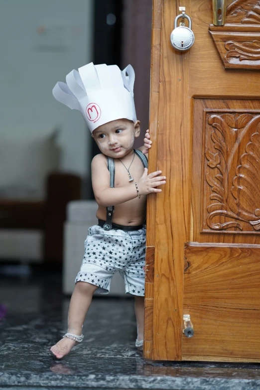 the little baby boy is dressed in his chef's hat