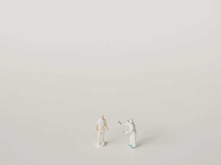 two figurines are standing side by side in the snow