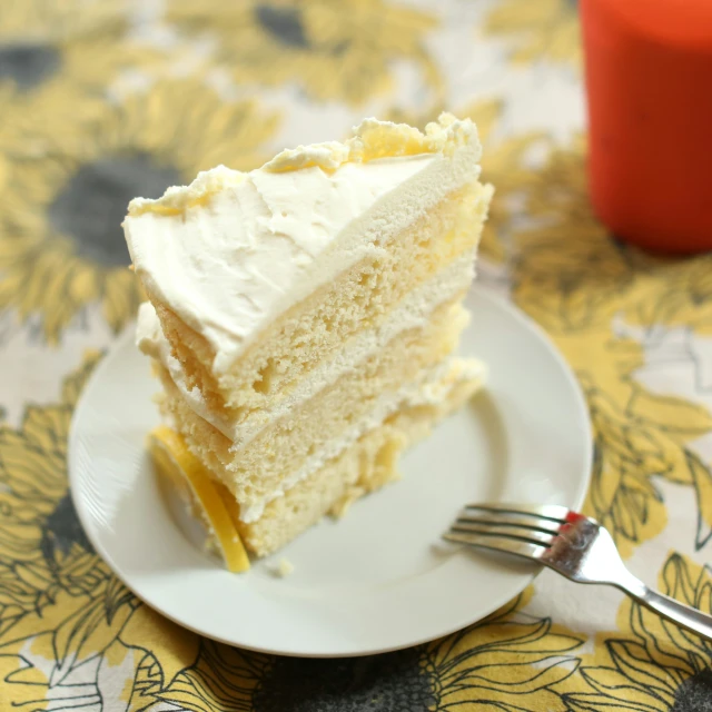 a slice of cake with white frosting on a plate