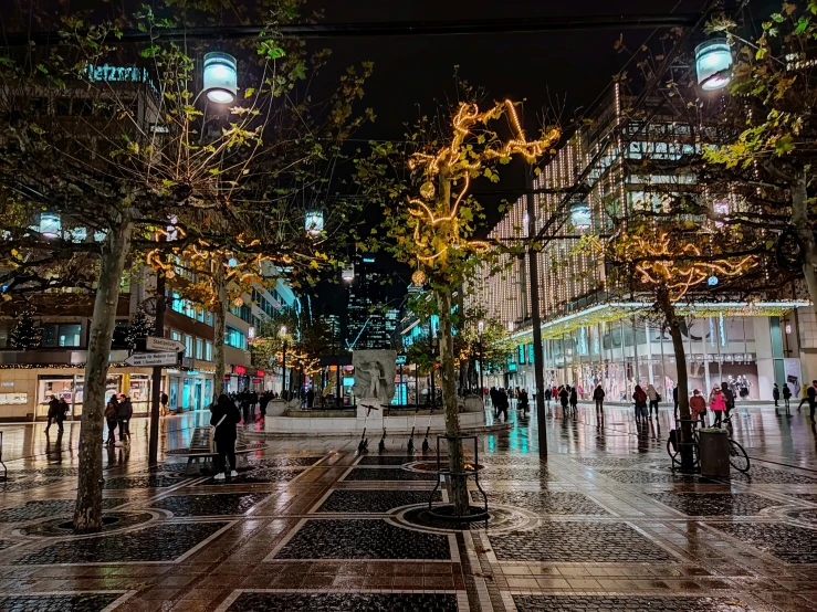 people standing on the sidewalk in a mall at night